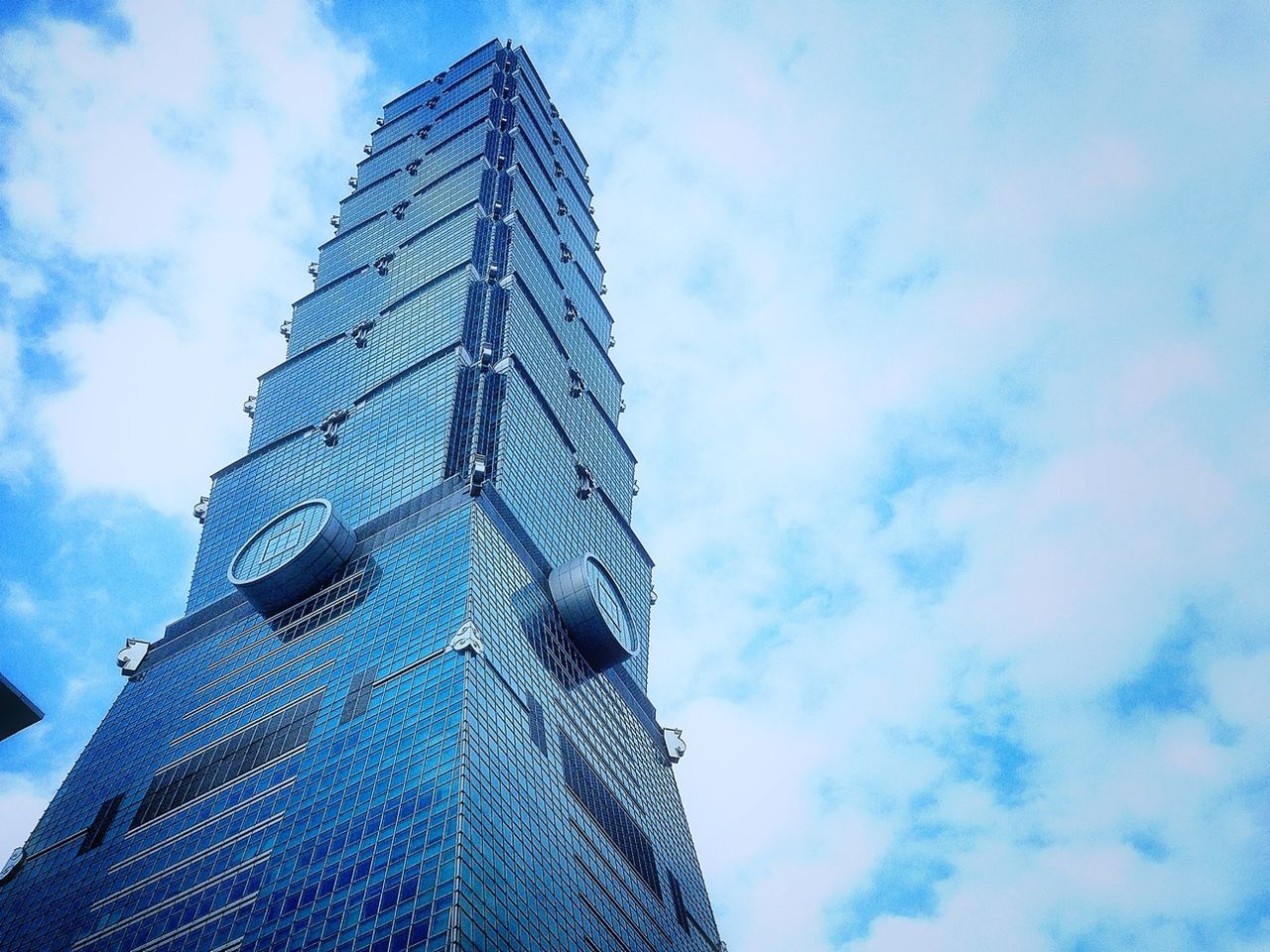 low angle view, sky, architecture, built structure, building exterior, cloud - sky, modern, tall - high, skyscraper, cloud, office building, blue, city, tower, cloudy, day, outdoors, tall, pattern, building