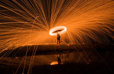 Man spinning wire wool at night