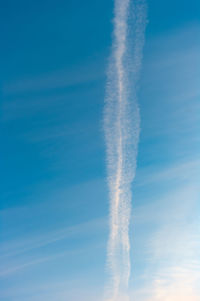 Low angle view of vapor trail against blue sky