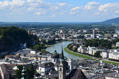 High angle view of buildings by river against sky