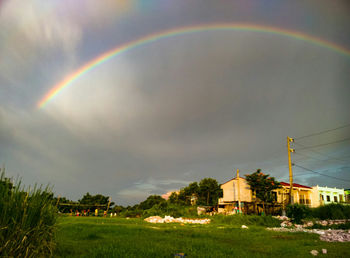 Rainbow over field against sky