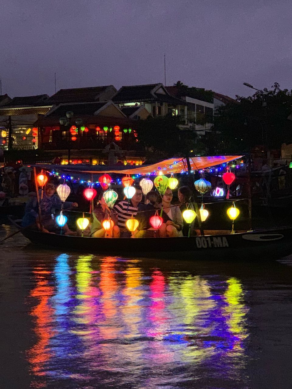 ILLUMINATED BUILDING BY RIVER AT NIGHT