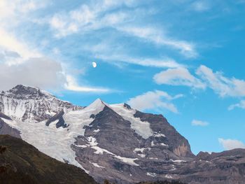 Scenic view of snowcapped mountain against cloudy sky