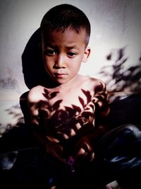 Portrait of cute boy sitting outdoors