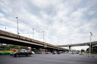 Bridge over street in city against sky