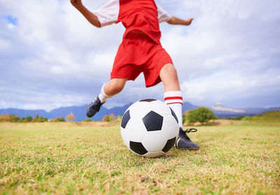 Low section of man playing soccer on field