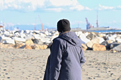 Man standing at beach against sky