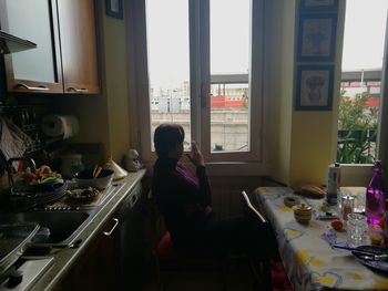 Man sitting on table by window