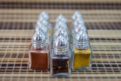 Close-up of spices arranged in glass containers on mat