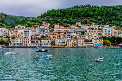 Sailboats in sea against buildings in city