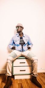 Young man sitting on wall at home