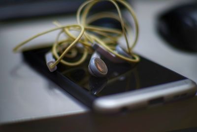 Close-up of headphones with smart phone on table