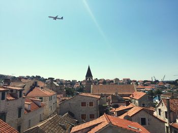 Low angle view of airplane flying against clear blue sky