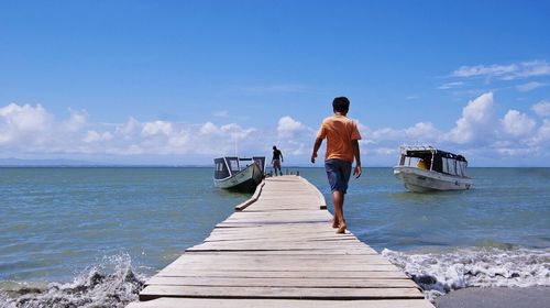 Rear view of woman standing on jetty