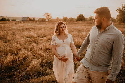 Rear view of couple standing on field