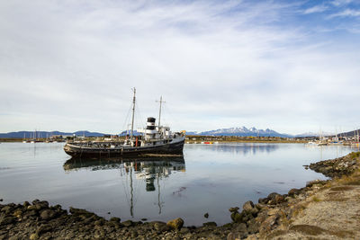 Sailboats moored on sea against sky