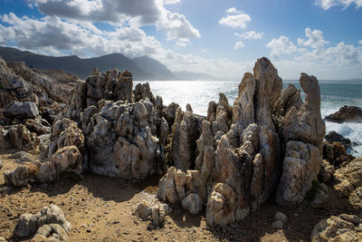 Panoramic view of rocks on beach against sky