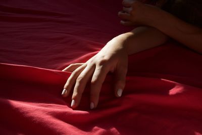 Low section of woman lying on bed