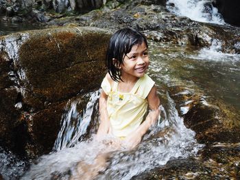 Happy girl sitting at stream