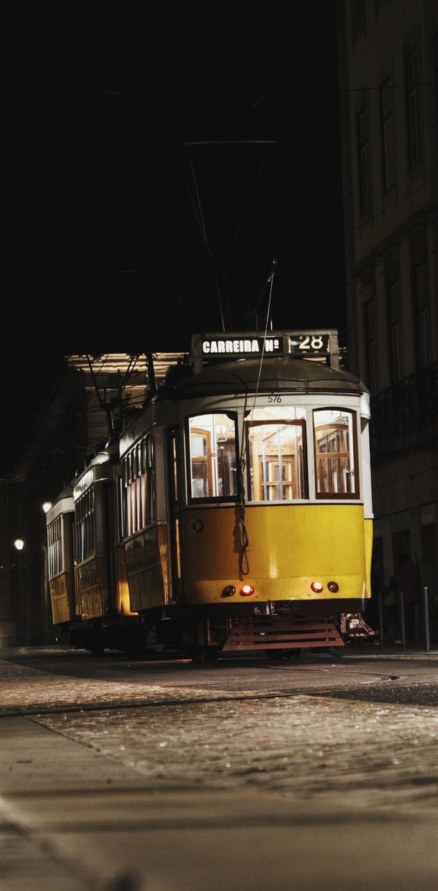 TRAIN ON ILLUMINATED STREET IN CITY