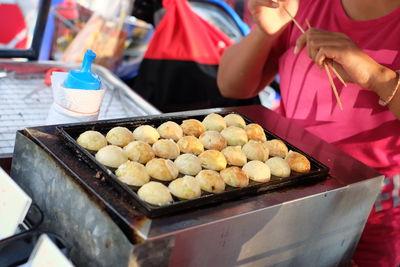 Midsection of woman preparing food outdoors