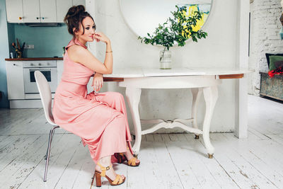 Glamorous woman sitting on chair at home