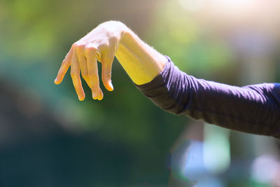 Cropped image of hand gesturing outdoors