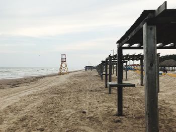 Pier on beach against sky