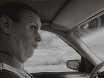 Portrait of man looking through car window