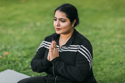 A young indian woman meditates with her eyes closed in the open air