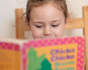 Young girl is reading a book intently