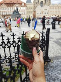 Midsection of person holding ice cream in citypraga of prague