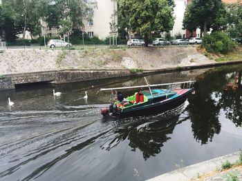 Boats moored on river by trees