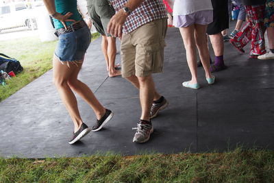 Low section of people standing on tiled floor