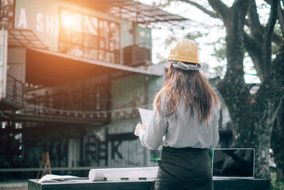 Rear view of woman standing against built structure