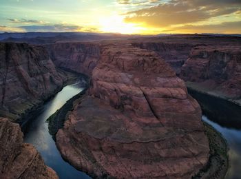 Scenic view of horseshoe bend against sky during sunset