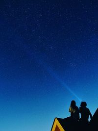 Low angle view of couple against star field