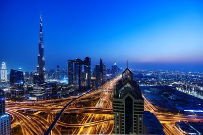 Aerial view of illuminated buildings against sky at night