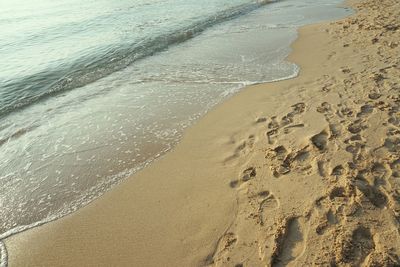 High angle view of footprints on sand at beach