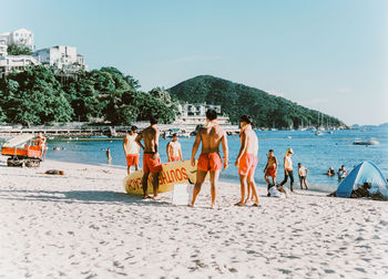 People at beach against sky