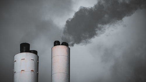 Smoke emitting from chimney against sky