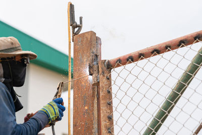 Welding hinges on the gate,work in construction site