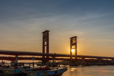 Bridge over river at sunset