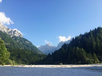 Scenic view of lake and mountains against blue sky