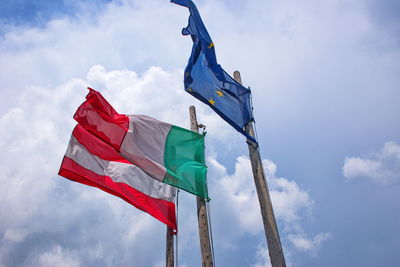 Low angle view of flags against blue sky