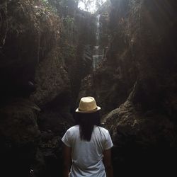 Rear view of woman standing in forest