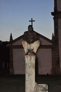 Low angle view of statue against building against sky