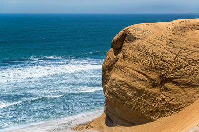 Scenic view of sea by rock formation