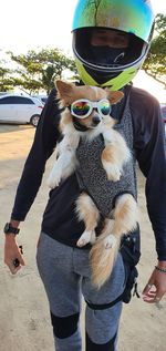 Midsection of man holding sunglasses with dog