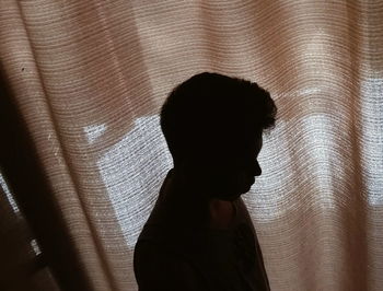 Silhouette of man against window